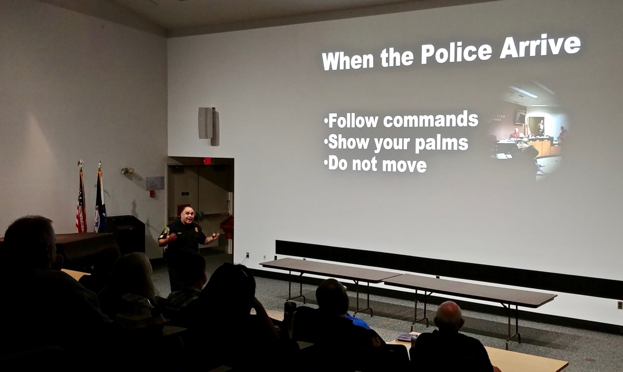 Image taken during presentation shows Sgt. Randy Cupp and slide indicating that when police arrive, you should follow co,,ands, show your palms and do not move unless ordered to do so.