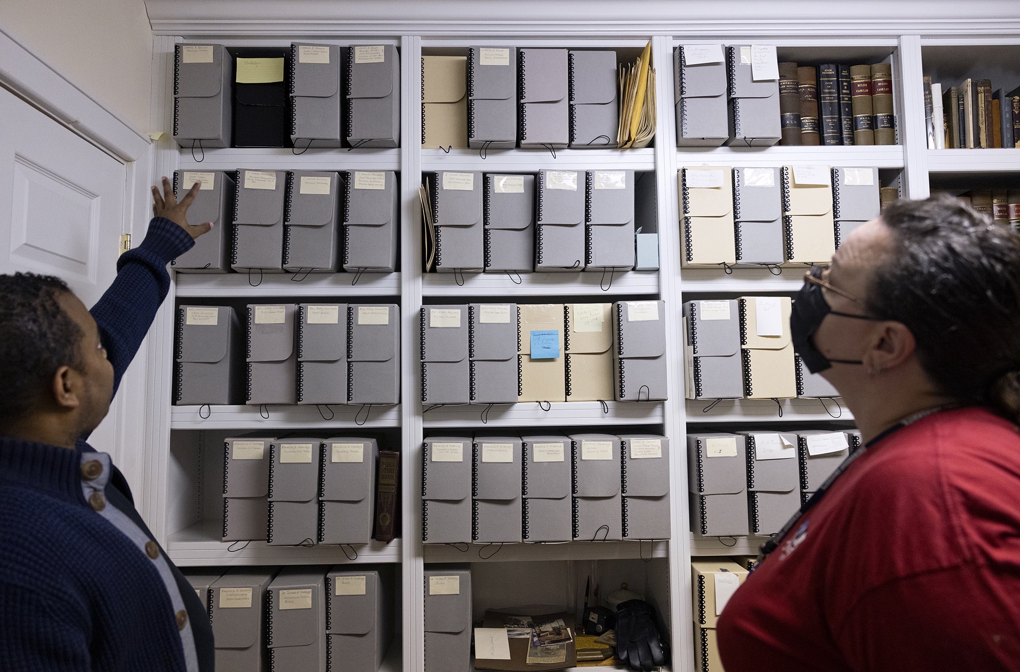 Newsome House Museum & Cultural Center’s Museum Assistant Tad Williams, left, and Jefferson Lab’s Archives and Record Specialist Melissa Erlandson, right, look over the museum’s archives in Newport News, Va. Jefferson Lab gifted approximately 44 archival boxes to the Newsome House on Friday, Dec. 16, 2022. (Photo by Aileen Devlin | Jefferson Lab)