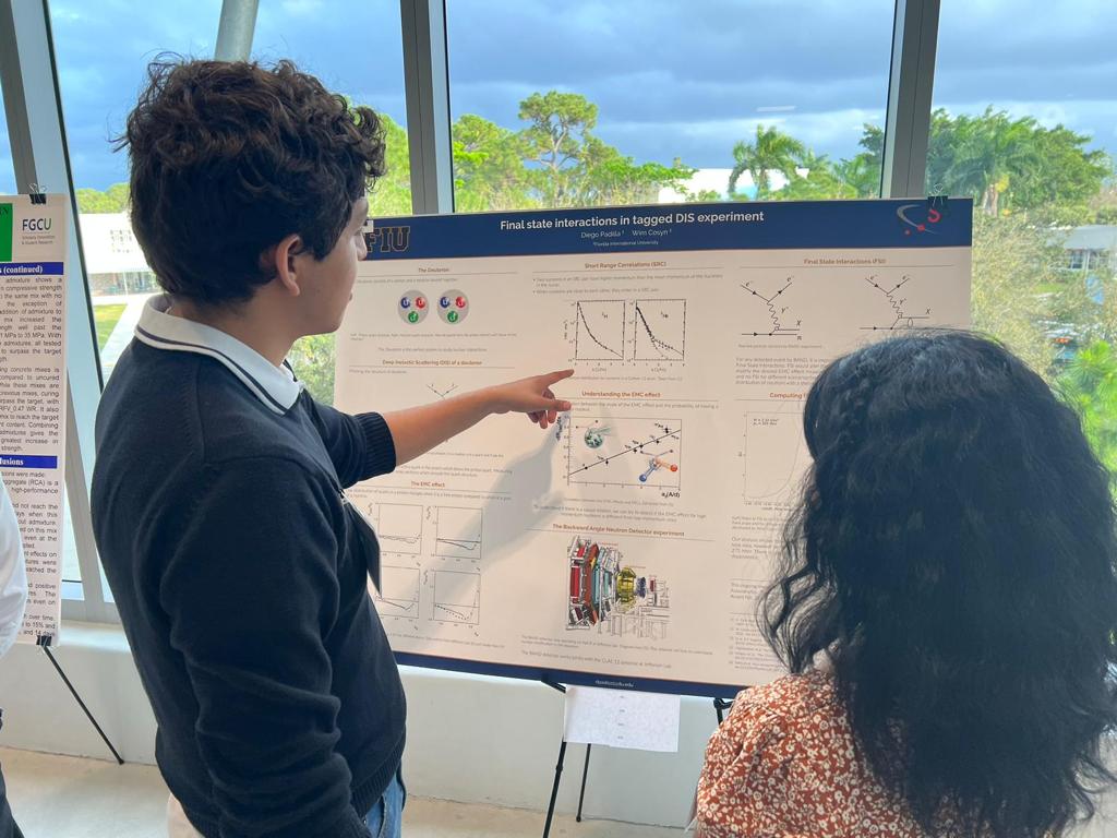 Diego Padilla Monroy presents his M/FURA research as a poster at a recent meeting, speaking with another attendee